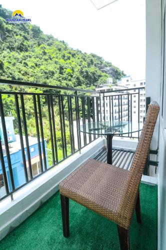 a rattan chair sitting on a balcony with a view at Mountain Pearl Hotel in Cat Ba