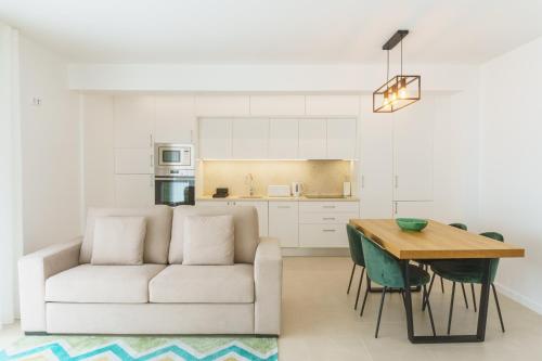 a living room with a white couch and a table at Marisol Mar in Nazaré