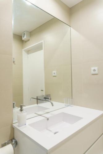 a bathroom with a sink and a mirror at Marisol Mar in Nazaré