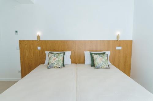 uma cama com duas almofadas em cima em Marisol Mar na Nazaré