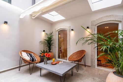 uma sala de estar com duas cadeiras e uma mesa em GuestReady - Luxury with Private Terrace in Lapa em Lisboa