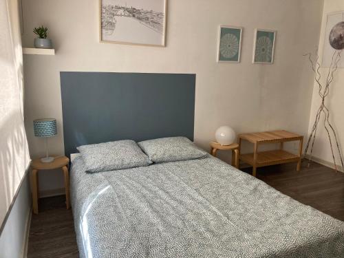 - une chambre avec un lit et deux tables de chevet dans l'établissement Studio Dragon avec gardien, à Marseille