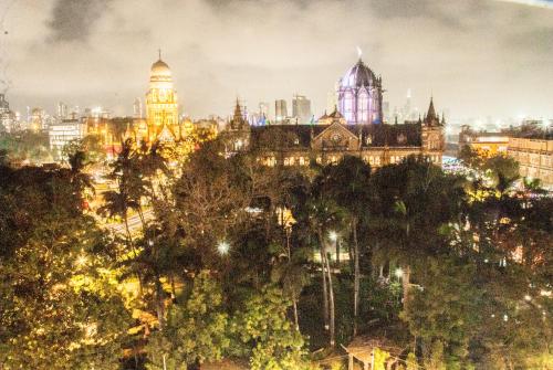 ムンバイにあるCity Hotelの明かりが灯る夜の街の景色