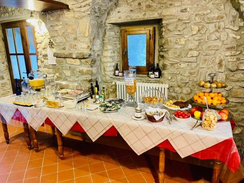 una mesa con comida en ella en una sala de piedra en Agriturismo Montagna Verde Apella, en Licciana Nardi