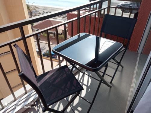 uma mesa de vidro e 2 cadeiras numa varanda em Apartamento Perla Costa del Sol em Fuengirola