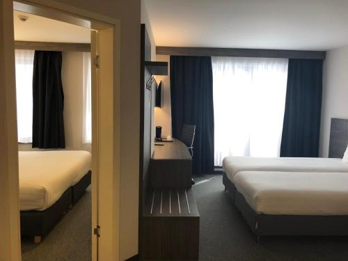 a hotel room with two beds and a mirror at Hotel Best Western City Centre in Brussels