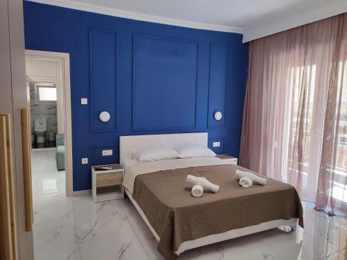 a blue bedroom with a bed with towels on it at JOY HOME in Kavála