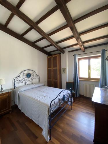 a bedroom with a bed and a large window at Villa Strada dei Monti Sibillini in Montefortino