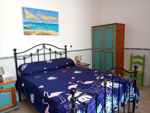 a bedroom with a bed and a painting on the wall at Beachfront House sea views near historic Cartagena in Cartagena