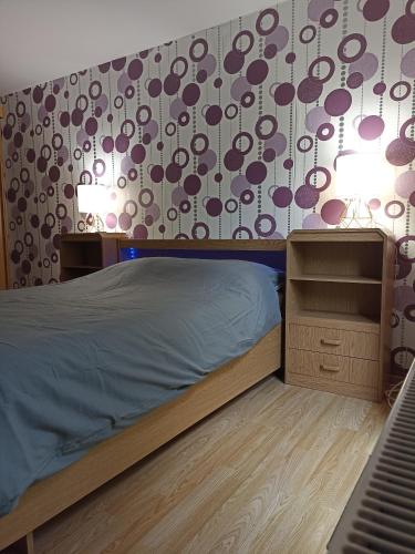 een slaapkamer met een bed en een muur met patronen bij Loft paisible sur les hauteurs du centre ville in Spa