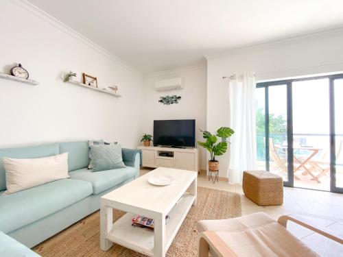 a living room with a blue couch and a tv at Meia-Praia Beach & Town Marina Apartment #1923 in Lagos