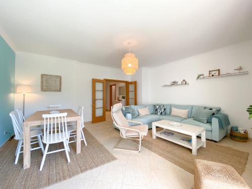 a living room with a blue couch and a table at Meia-Praia Beach & Town Marina Apartment #1923 in Lagos