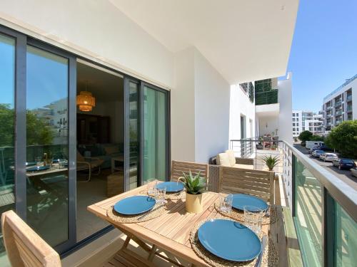 a balcony with a wooden table with blue plates at Meia-Praia Beach & Town Marina Apartment #1923 in Lagos