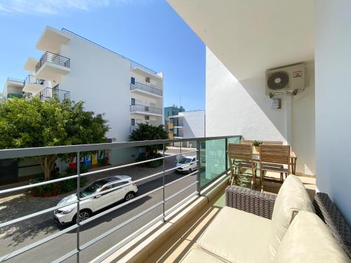 a balcony with a car on a city street at Meia-Praia Beach & Town Marina Apartment #1923 in Lagos