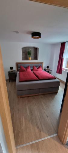 een slaapkamer met een bed met rode kussens erop bij Ferienwohnung Raabsteine in Bad Gottleuba