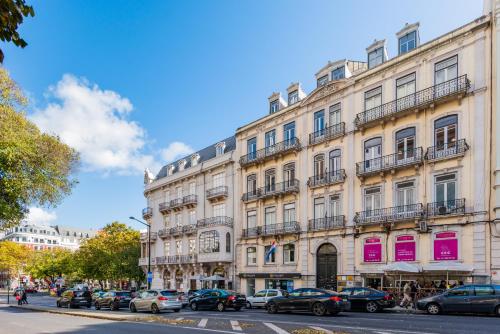 een groot wit gebouw met auto's geparkeerd voor het bij Lisbon Boulevard in Lissabon