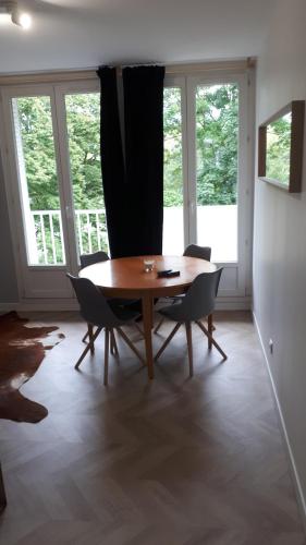une salle à manger avec une table et des chaises en bois dans l'établissement Le Mangin - Rent4night Grenoble, à Grenoble