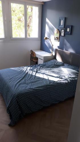 una camera con letto e scrivania con lampada di Le Mangin - Rent4night Grenoble a Grenoble