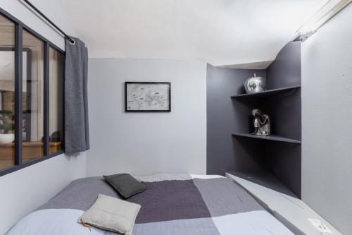 - une chambre avec un lit et des étagères sur le mur dans l'établissement Midoon guest - LA VERRIERE DES TERREAUX - Lyon 1er, à Lyon