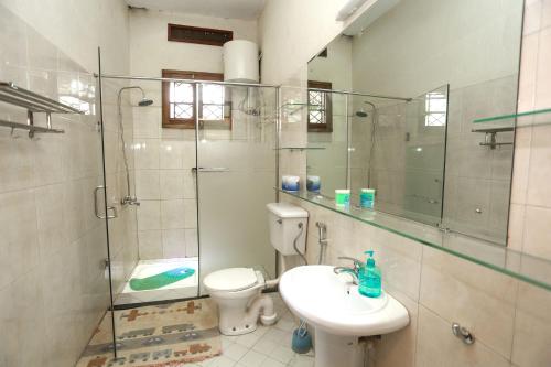 e bagno con servizi igienici, lavandino e doccia. di Remarkable 2-Bed Cottage Along Gayaza road a Kampala