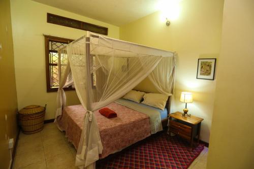 una camera con letto a baldacchino di Remarkable 2-Bed Cottage Along Gayaza road a Kampala