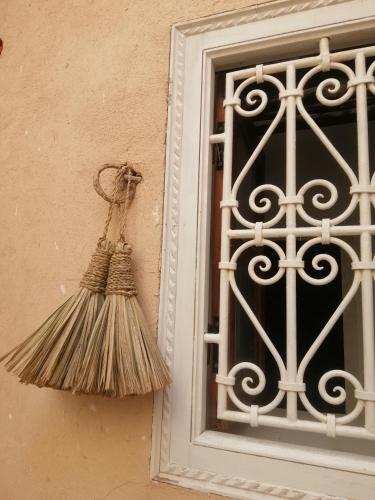 a broom hanging on a wall next to a window at Hostel Laksour in Marrakech