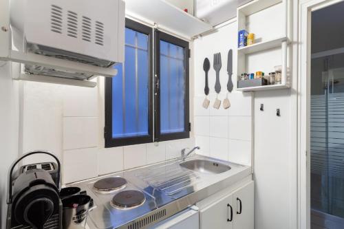 une petite cuisine avec un évier et une fenêtre dans l'établissement Midoon guest - LA VERRIERE DES TERREAUX - Lyon 1er, à Lyon