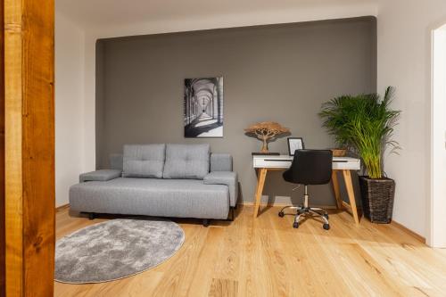 a living room with a couch and a desk at Cozy Studio Apartment Located in Vienna's Vibrant City Center in Vienna