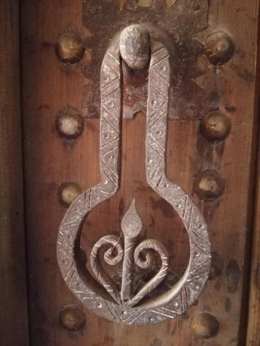 a metal door handle with a snake on a wooden door at Hostel Laksour in Marrakech