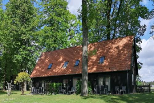 a house with a red roof and tables and chairs at Beekenhof in Bommelsen
