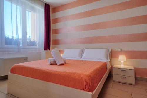 a bedroom with a bed with a striped wall at The Lighthouse Rooms in Lazise