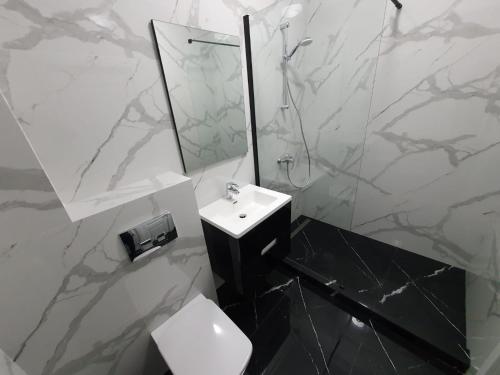 een witte badkamer met een wastafel en een spiegel bij SUMMER HOME in Eforie Nord