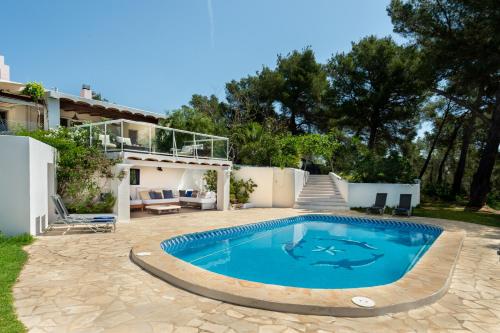 a swimming pool in front of a house at Villa Armonía in San Antonio