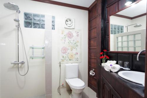 a bathroom with a toilet and a shower and a sink at Chandara Boutique Hotel in Vientiane