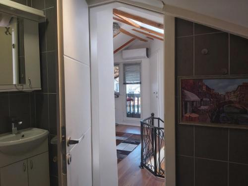 eine offene Tür zu einer Küche mit einem Waschbecken in der Unterkunft Apartment Harisson in Mostar