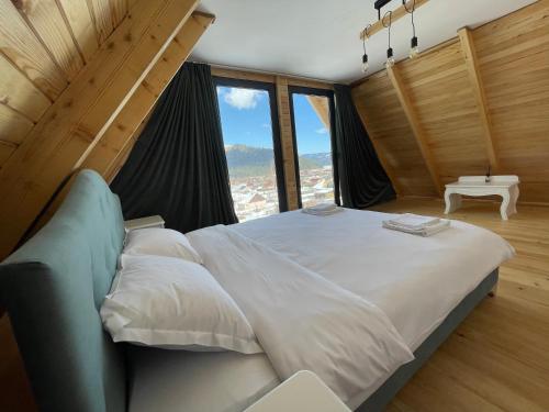 a large bed in a room with a large window at Cabana NOR in Bistricioara