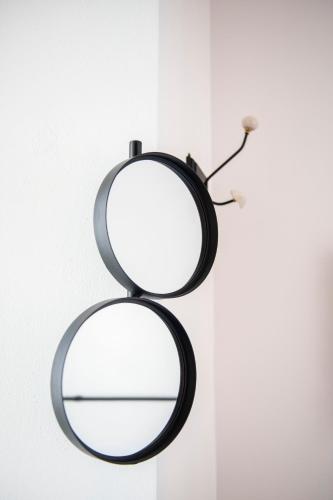 a round mirror hanging on a white wall at Arya Nobile Dimora in Carovigno
