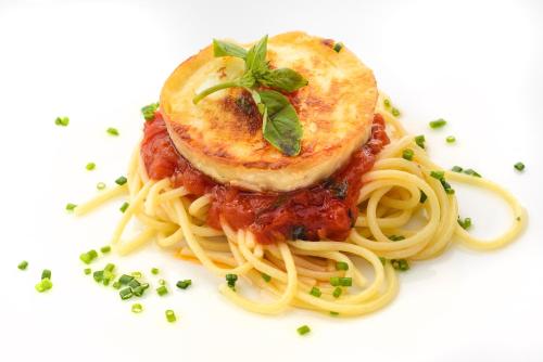a plate of pasta with sauce and cheese on top at Hotel Saliecho in Formigal