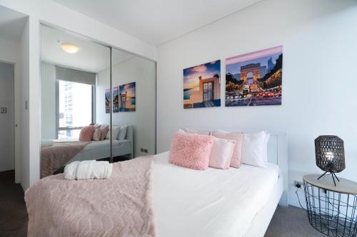 a bedroom with a white bed with pink pillows at 152 City Rest With Views High Upparking Sleeps 2 in Perth