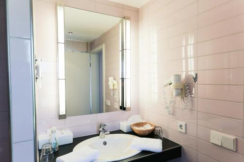 Hotel Albblick Bad Boll في باد بول: حمام مع حوض ومرآة
