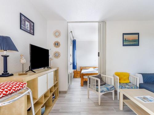 a living room with a tv and a couch at Apartment Les Maisons de l'Océan-7 by Interhome in Lacanau-Océan