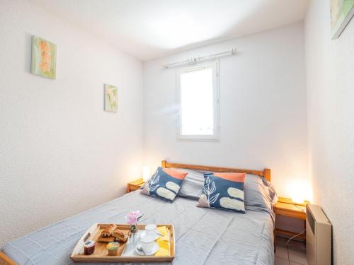 une chambre avec un lit avec un plateau dessus dans l'établissement Apartment Les Terrasses du Lac-7 by Interhome, au Grau-du-Roi