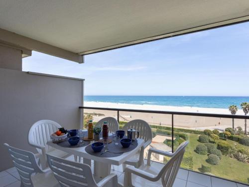 a table and chairs on a balcony with a view of the beach at Apartment Grand Sud-2 by Interhome in Canet-en-Roussillon