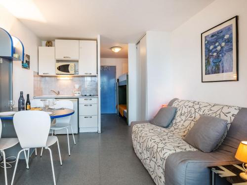 a living room and kitchen with a couch and a table at Apartment Copacabana-2 by Interhome in Canet-en-Roussillon