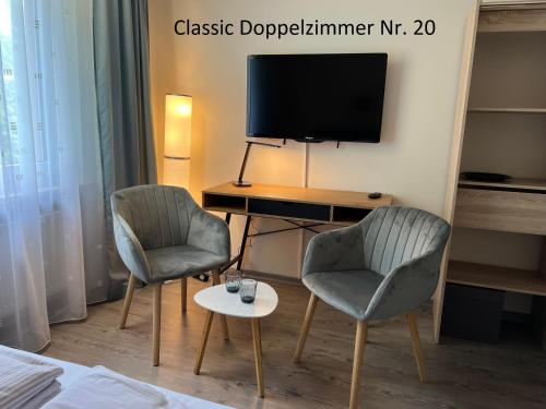 a room with two chairs and a desk with a television at HoteLPension am Thermalbad in Bad Nenndorf