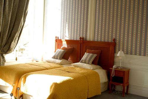 a bedroom with two beds and a window at La Gourmandine in Châtellerault