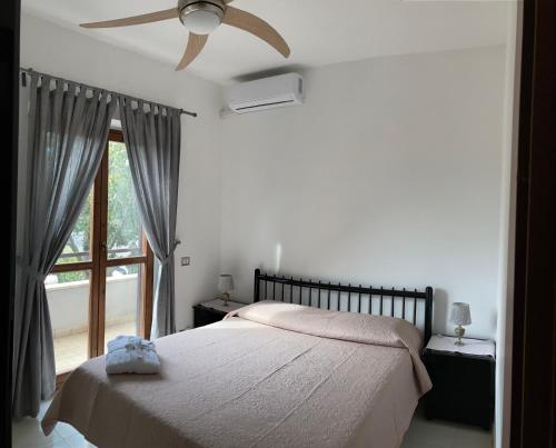 una camera con letto, ventilatore a soffitto e finestra di La Luna sul lago a Trevignano Romano