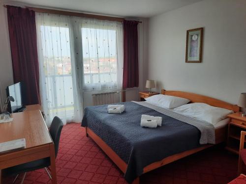 a bedroom with a bed with two towels on it at PATRIA HOTEL in Trutnov