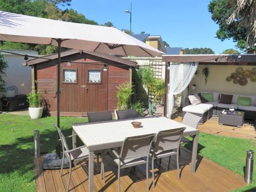 a patio with a table and an umbrella at Holiday Home Les Camélias - LBE110 by Interhome in Labenne