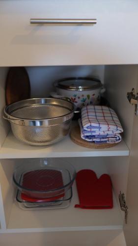 a shelf with some pans and plates in a kitchen at Ctrl Alt Del Apartment S76 in Kopaonik